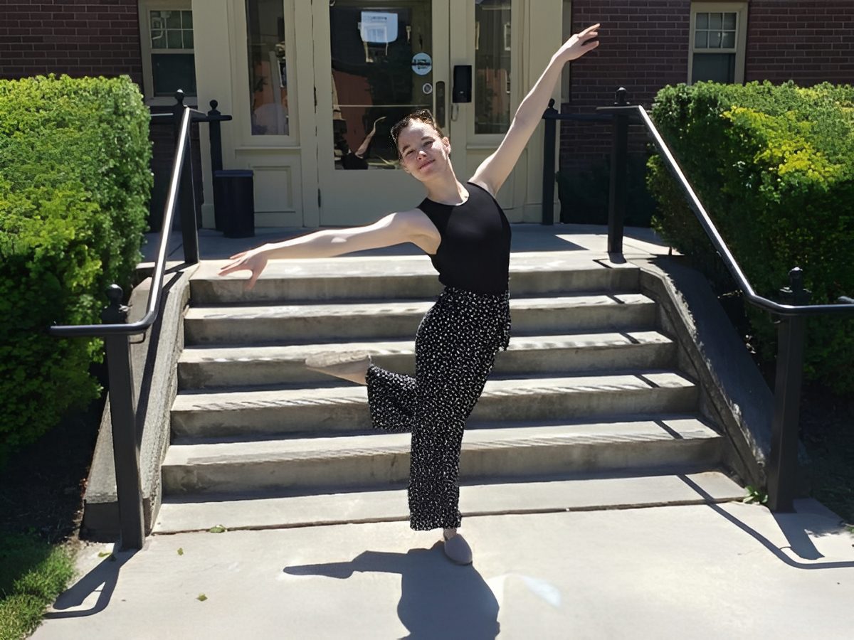 Woman in black outfit striking a dance pose