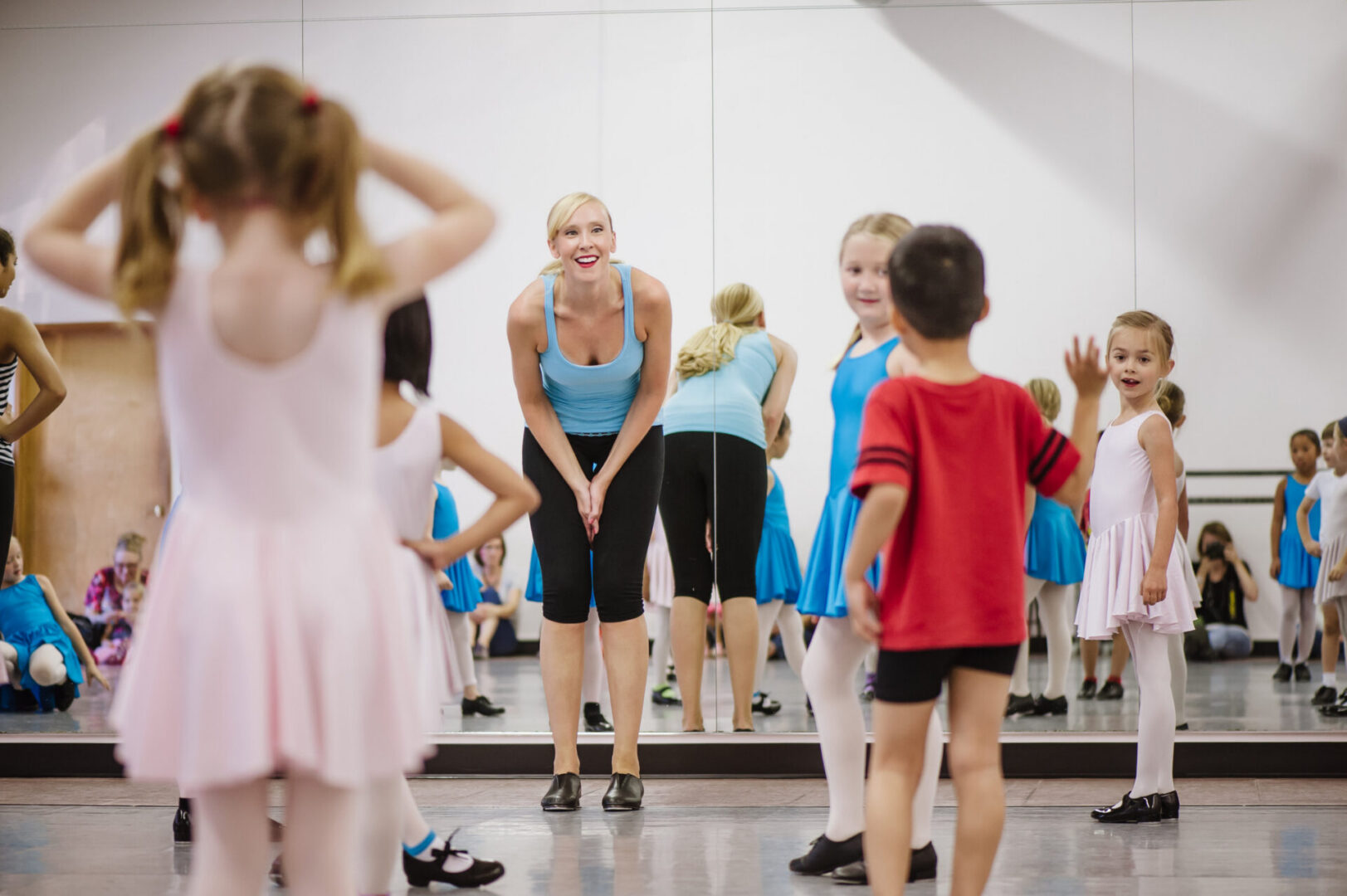 Ballet class with smiling instructor and children