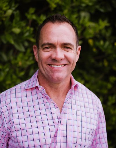 Smiling man in pink checkered shirt
