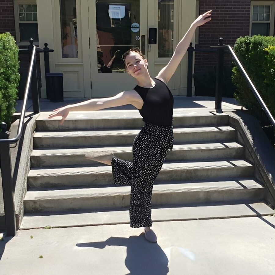 Woman in black outfit striking a dance pose